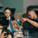 Młodzi inżynierowie pracują wspólnie nad projektem robota w warsztacie